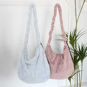 Leopard print plush hobo shoulder bags in blue and pink on a minimalist white hanger