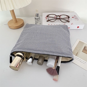 Detailed view of seersucker striped makeup bag showing large capacity for skincare products