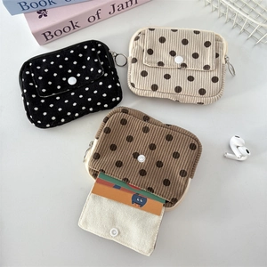 Three corduroy polka dot coin purses in black brown and beige colors for storage