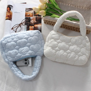 Detail of blue and white quilted cloud mini bags showing interior storage and puffy fabric