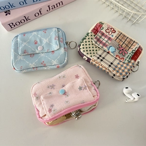 Detailed view of floral corduroy makeup bags with metal ring and zipper closure