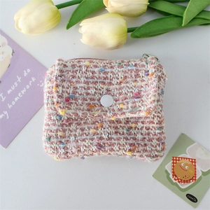 Detailed macro view of pink tweed coin purse with pearl texture and metal zipper