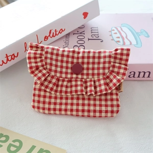 Close-up of red gingham pouch with ruffle edge flap and decorative button detail
