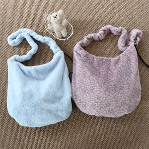Plush leopard print and light blue shoulder bags with soft adjustable straps on brown rug