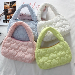 Close-up of four macaron-colored quilted cloud mini handbags in a lifestyle flat lay