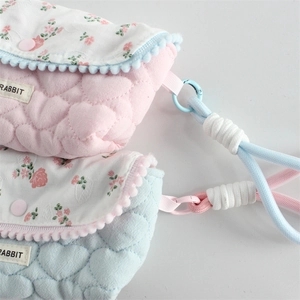 Detail of quilted floral pencil case with heart patterns and rabbit tag labels