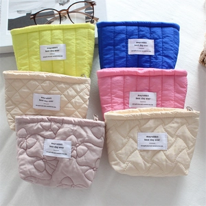 Detailed display of quilted cosmetic bags in multiple colors and textures with soft padding