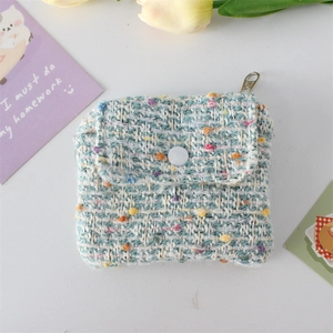 Detail of tweed coin purse with white snap button and metal zipper closure