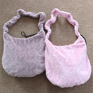 Detail of plush shoulder bags with ruffled straps and leopard heart print patterns