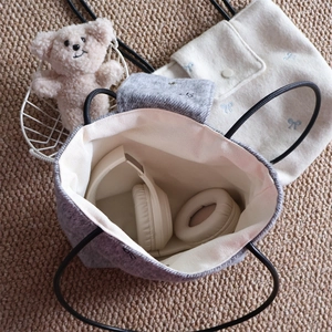 Felt tote bags with blue bow embroidery and over-ear headphones inside, grey and beige