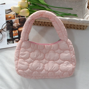 Detailed view of pink quilted cloud handbag with soft puffy fabric and floral accents