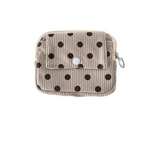 Portable corduroy coin purse with brown polka dots and front snap pocket closure