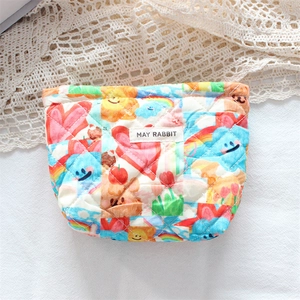 Detailed view of quilted cotton cosmetic bag with colorful cartoon prints and brand tag