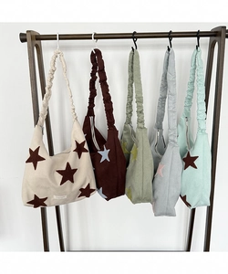 Close-up of five-pointed star embroidery and scrunchie strap on corduroy shoulder bags