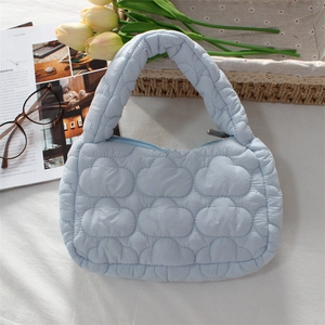 Detail of light blue quilted mini cloud bag showing soft padded nylon texture and stitching