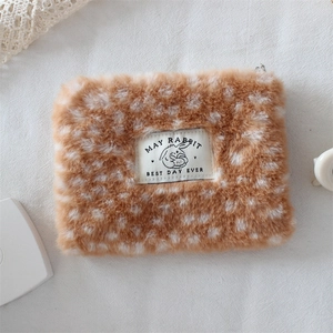Macro shot of fluffy deer print plush pouch texture and black rabbit brand label