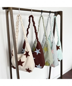 Detail of star embroidery and ruffled shoulder straps on suede hobo bags in various colors