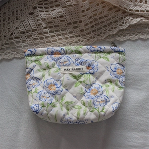 Detailed macro view of quilted floral cosmetic bag with May Rabbit label and zipper