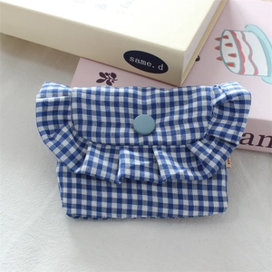Detailed close-up of blue gingham cotton pouch featuring delicate ruffled edges and snap button
