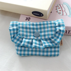 Detailed view of blue gingham ruffle mini pouch with button closure and rabbit label