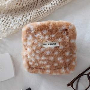 Close-up of deer pattern plush makeup bag with soft faux fur texture and branded tag