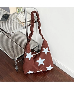 Detailed shot of star embroidery on brown suede shoulder bag with ruffled strap