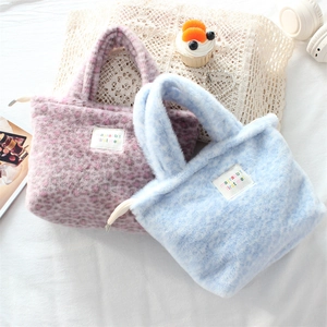 Close-up of soft plush leopard print handbags in pink and blue with stylish fabric labels