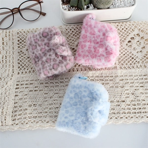 Macro detail of three plush leopard print wallets on vintage lace background