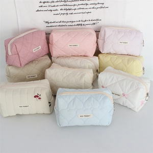 Close-up of quilted heart patterns and embroidery on colorful cosmetic bags