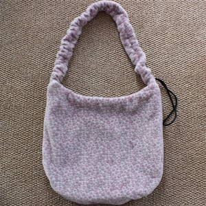 Detail of plush faux fur shoulder bag featuring pink leopard print and ruched strap