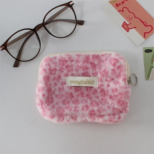 Gros plan du porte-monnaie en peluche léopard rose avec fermeture éclair et étiquette