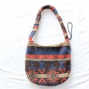 Detail of tribal pattern plush shoulder bag featuring colorful geometric knit and soft texture