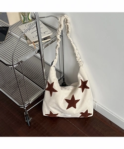 Detail of star embroidery on cream shoulder bag with stylish scrunchie strap design
