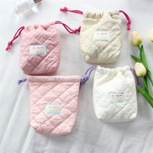 Detailed view of quilted cotton camera pouches with drawstring and soft floral texture