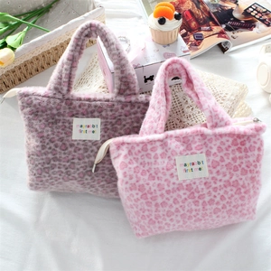 Detail view of pink and purple leopard print plush tote bags with soft fur texture