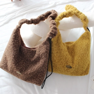 Detail of plush tote bags with ruched handles and handmade metal plate engraved