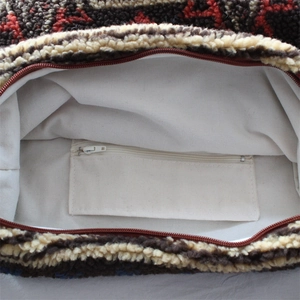 Detailed interior of plush tote bag with white canvas lining and small zippered pocket