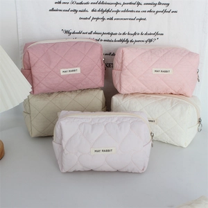 Detailed view of quilted heart pattern cosmetic bags with metal zippers in five colors