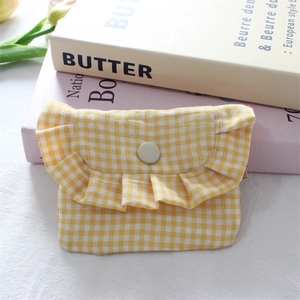 Detail of yellow gingham mini storage bag with elegant ruffle trim and snap closure