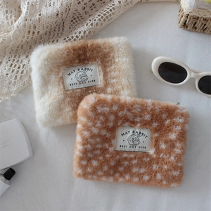 Macro shot of faux rabbit fur makeup bag with brown deer pattern and zip closure