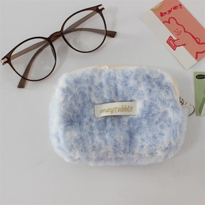 Détail du porte-monnaie peluche léopard bleu avec zip cœur et étiquette de marque