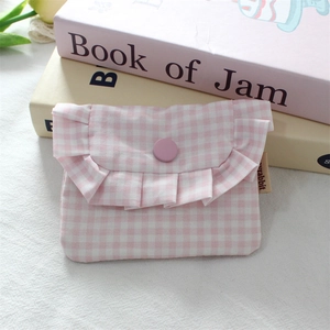 Close-up of pink checkered mini storage pouch with ruffle trim and snap button closure