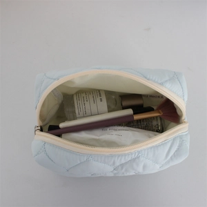Spacious interior of light blue quilted cosmetic bag with diamond stitching