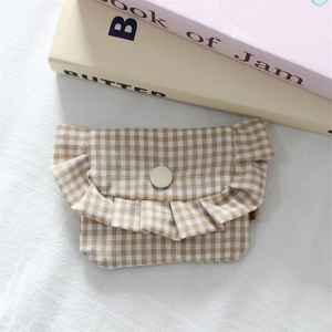 Close-up of yellow gingham mini pouch with ruffle edge and snap button closure