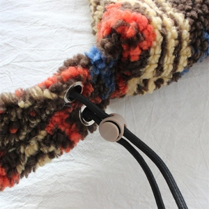 Detail of colorful shearling texture with black drawstring and adjustable buckle