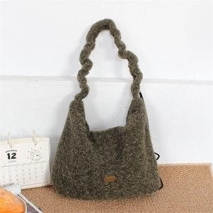 Detail of green plush knit shoulder bag showing textured boucle fabric and pleated strap