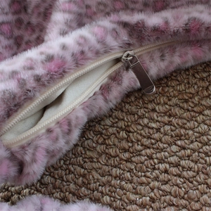 Macro shot of metal zipper detail and light lining on pink leopard plush bag fabric