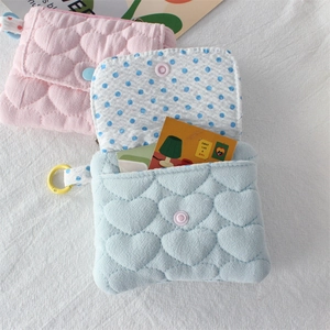 Detail showing heart-quilted fabric wallets with polka dot lining and snap closure
