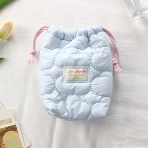 Close-up of sky blue quilted camera pouch with pink drawstring and soft cloud texture