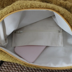 Detail view of plush shoulder bag interior with white canvas lining and a zipper pocket